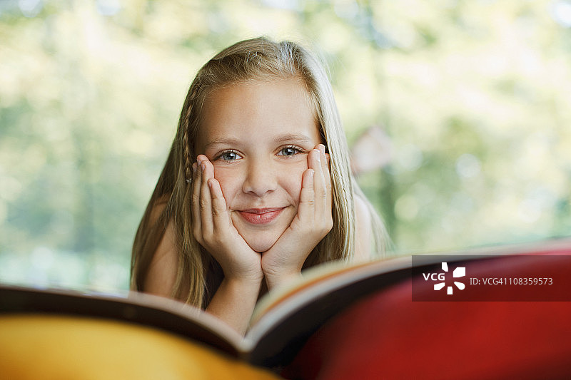 微笑的女孩在看书图片素材
