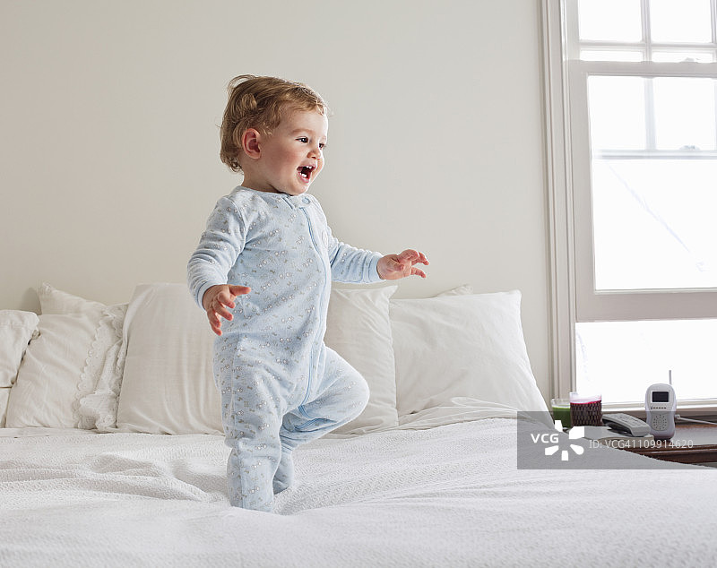 微笑的婴儿在床上行走图片素材