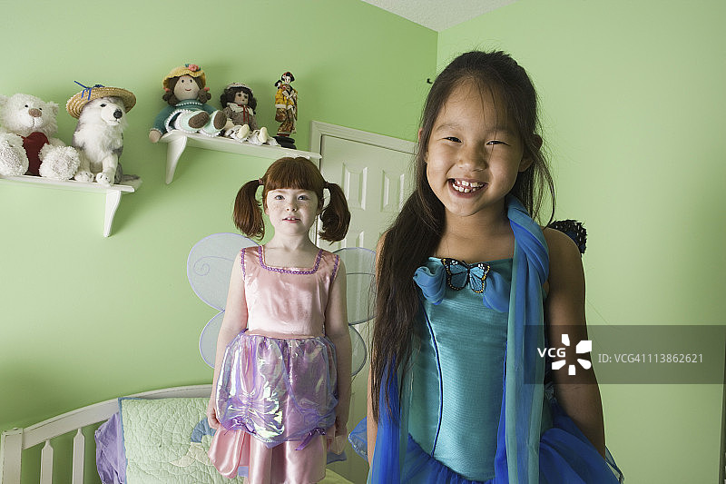 两个穿着戏服的小女孩站在床上图片素材