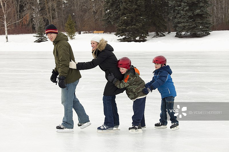 一家人一起在室外溜冰场滑冰图片素材