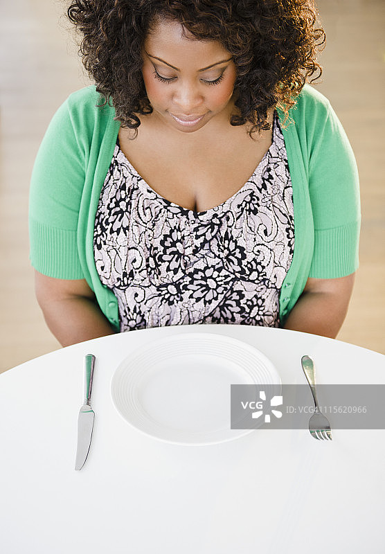 一个非裔美国女人看着空盘子图片素材