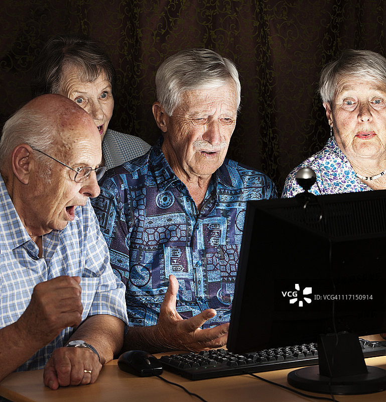 四个老人被电脑显示器上的图像震惊了图片素材