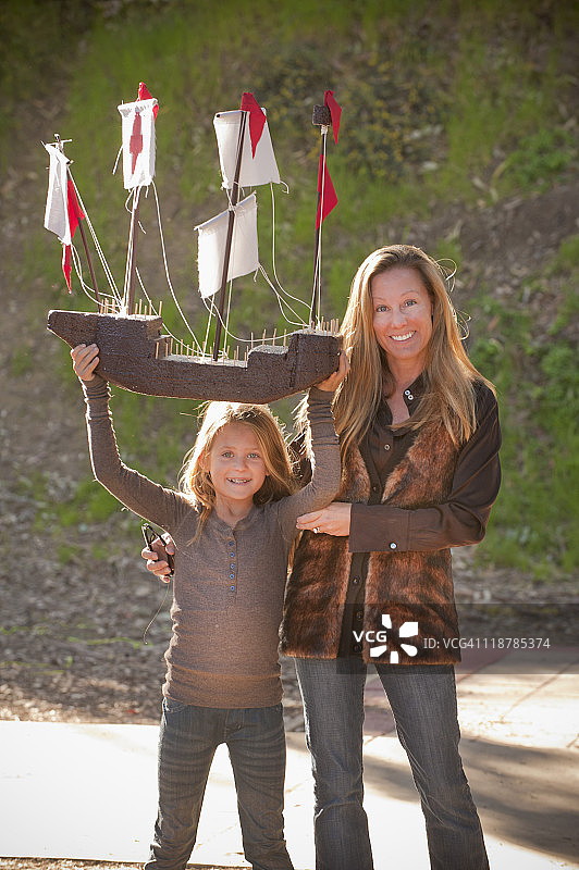 一个四年级的小女孩和妈妈一起亲手做帆船图片素材