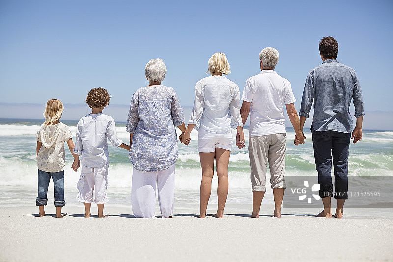 一个家庭的后视图从海滩看海景图片素材