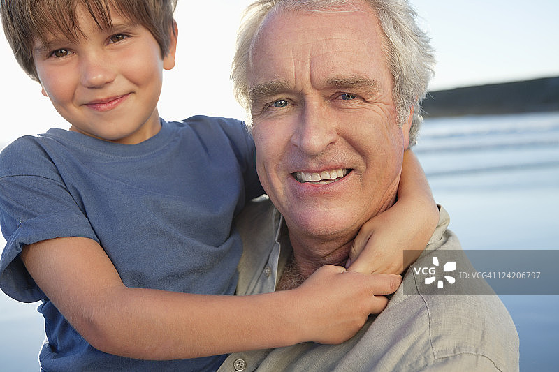 高级男子与孙子在海滩上玩的特写图片素材