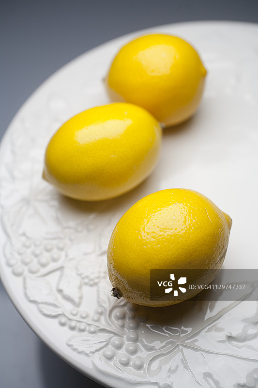 三个迈耶柠檬放在白色盘子里图片素材