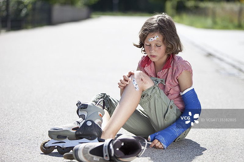 德国，巴伐利亚，一名受伤的女孩坐在公路上图片素材