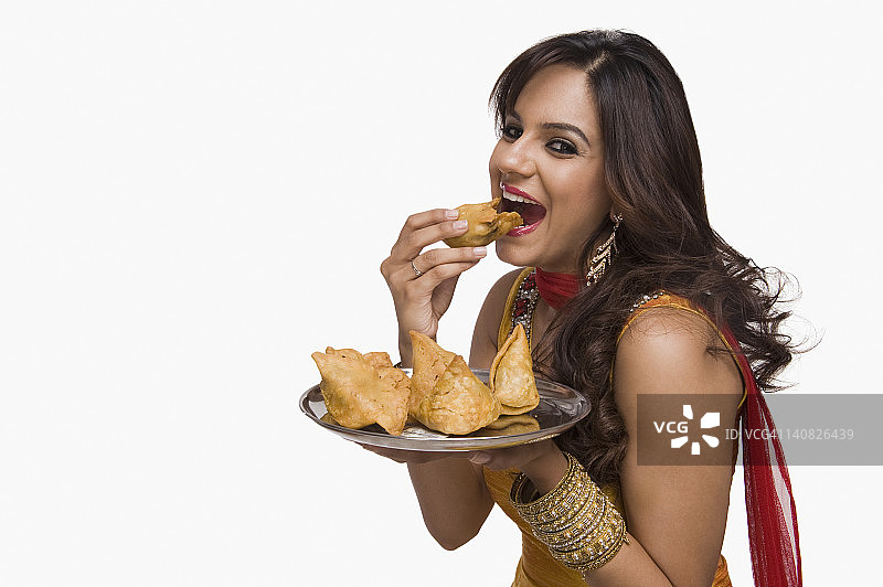 吃印度传统小吃萨莫萨的女人图片素材