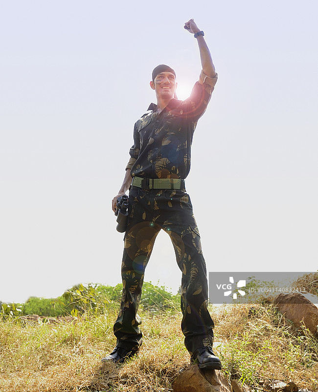 士兵站在田里庆祝他的成功图片素材