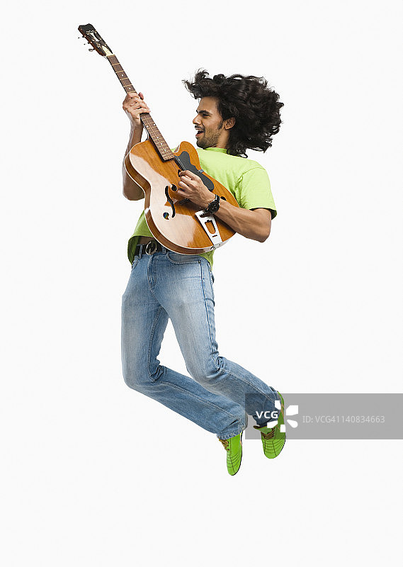 一个弹吉他的人在空中跳图片素材