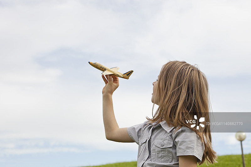 德国，巴伐利亚，女孩在公园里玩模型飞机图片素材