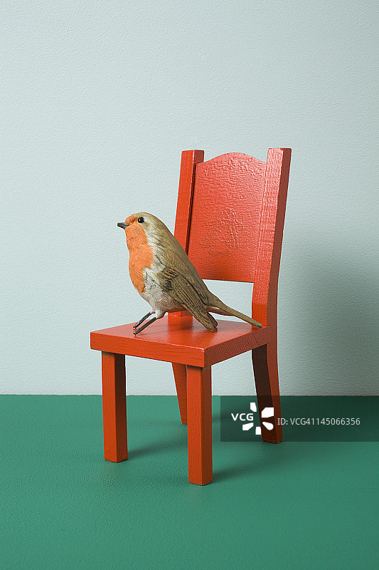 一只仿鸟坐在小椅子上图片素材