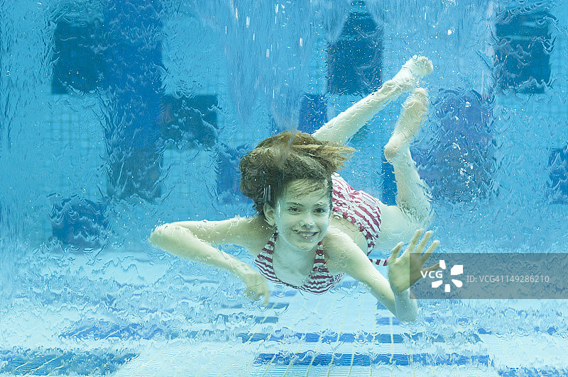 女孩在游泳池的水下游泳图片素材