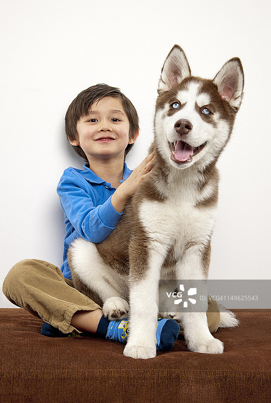男孩的小狗坐在他的腿上图片素材