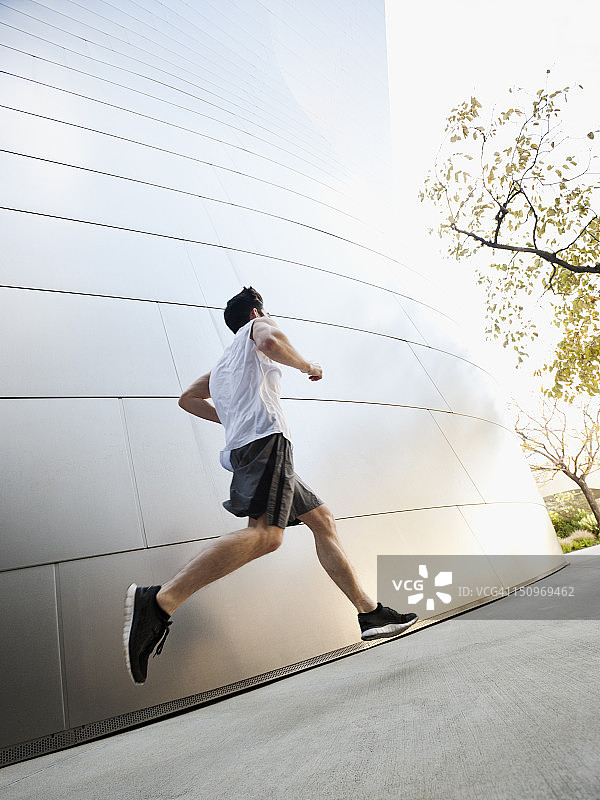 美国，加利福尼亚，洛杉矶，一个年轻人在城市街道上奔跑图片素材