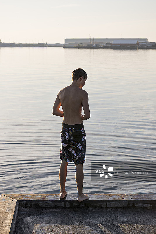 穿泳裤看水的男孩图片素材