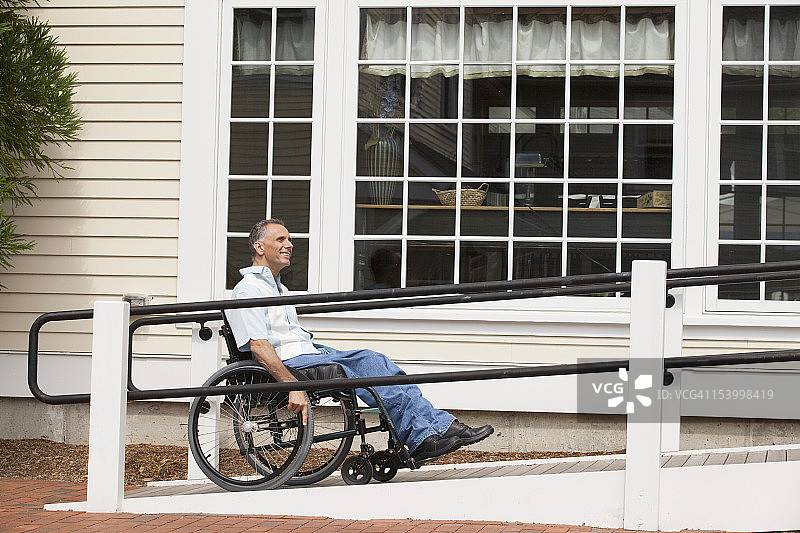 脊髓损伤的人坐在轮椅上使用无障碍的坡道图片素材