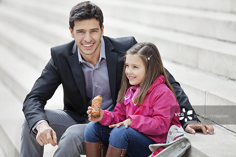 一个男人和他的女儿坐在一起吃巧克力图片素材