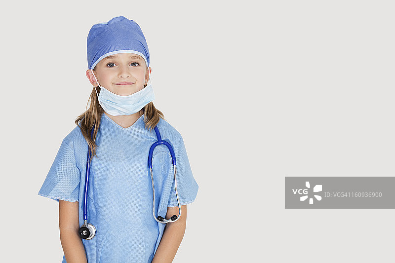 肖像的年轻女孩在外科医生的服装对灰色背景图片素材