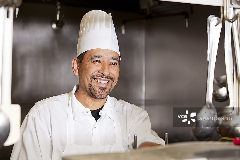 一个微笑的厨师在餐厅厨房的肖像图片素材