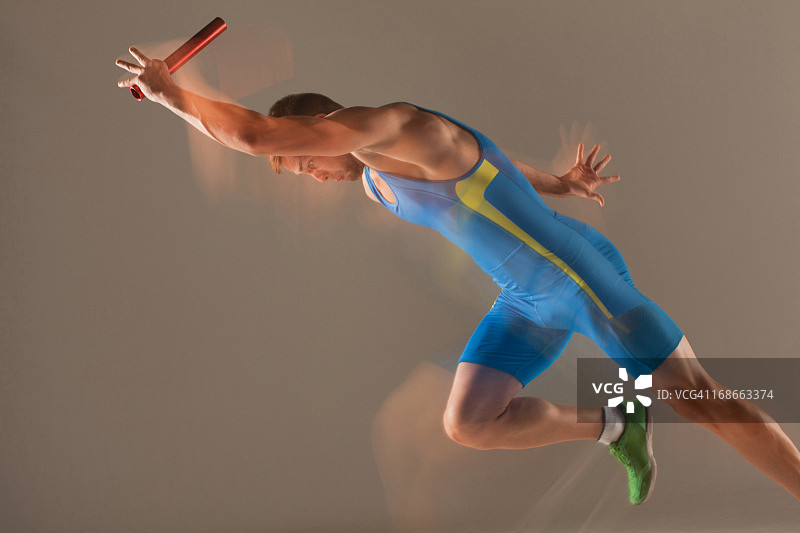 运动员拿着接力棒跑步的模糊画面图片素材