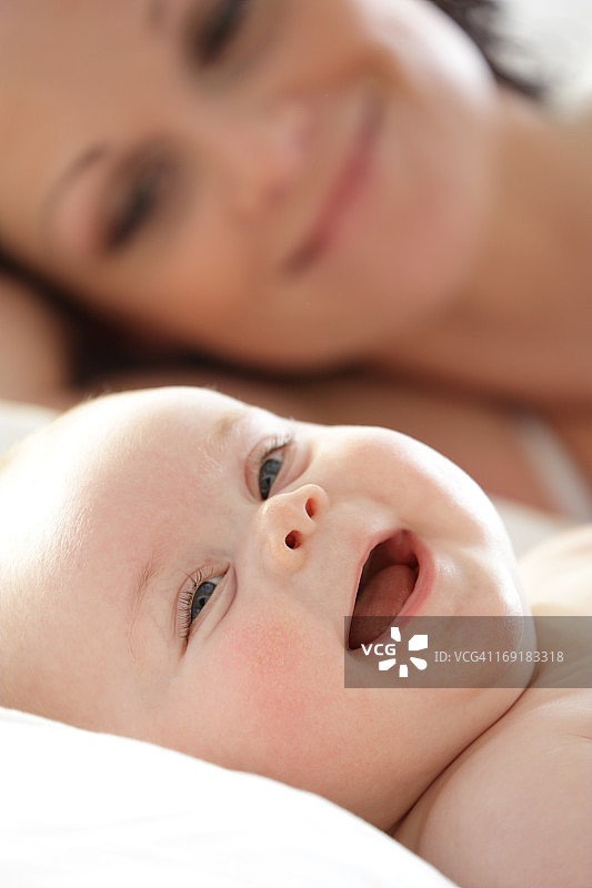 母亲和婴儿躺下微笑图片素材