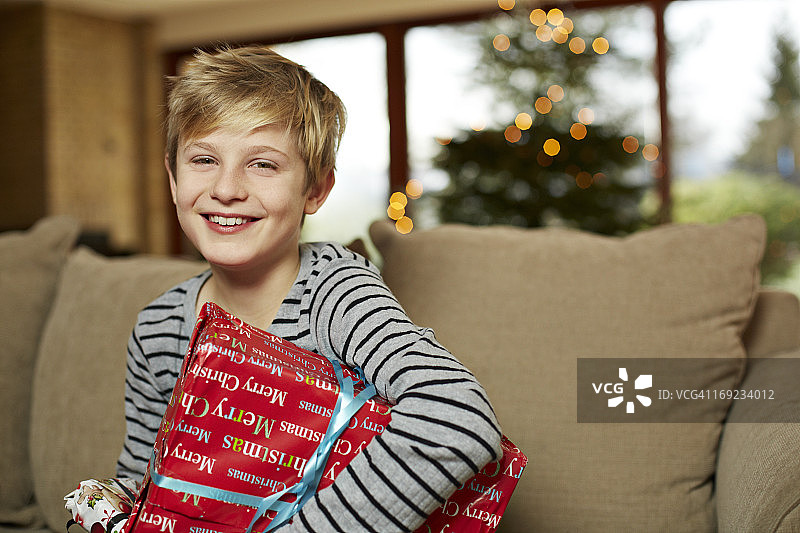 可爱的男孩拿着圣诞礼物笑图片素材