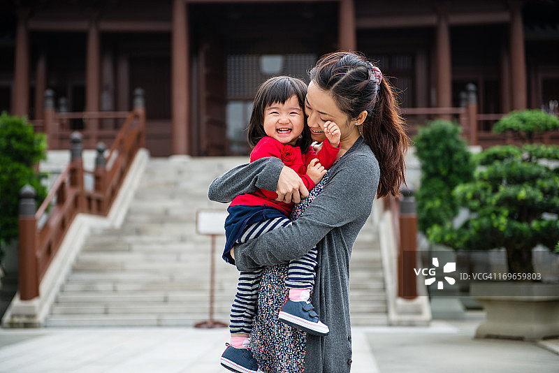 妈妈抱着孩子开心地在中国花园图片素材