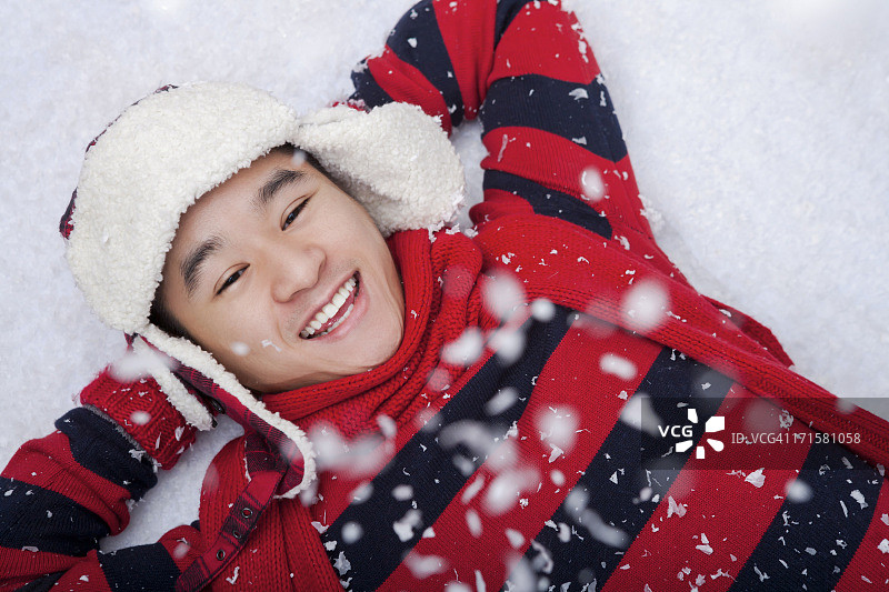 微笑的男人躺在雪地上图片素材