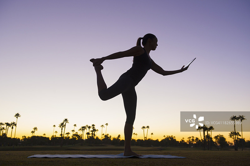 日出时，混血女子练习瑜伽的剪影图片素材