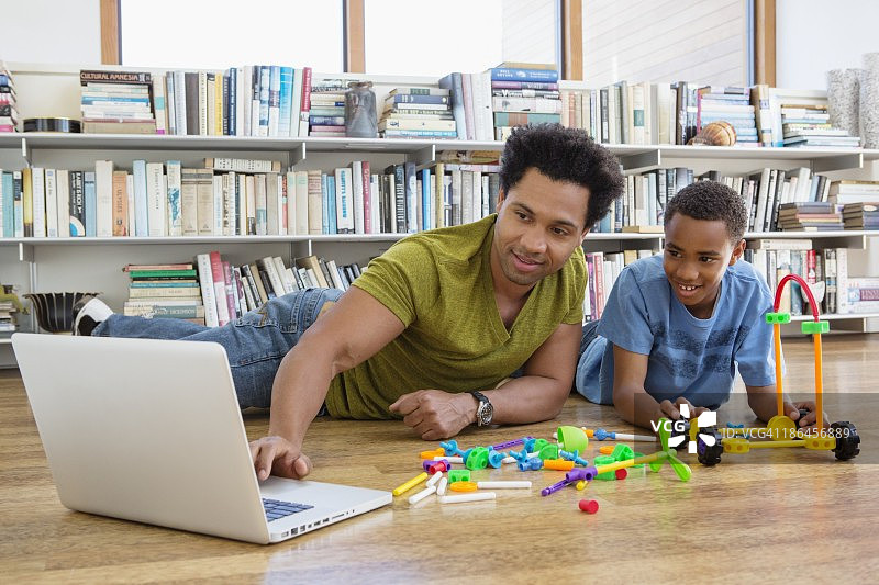 父亲和儿子(10-11)使用数字平板电脑图片素材