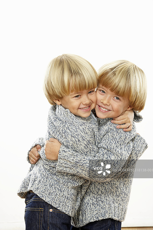 双胞胎男孩(3-5)拥抱，微笑，肖像图片素材