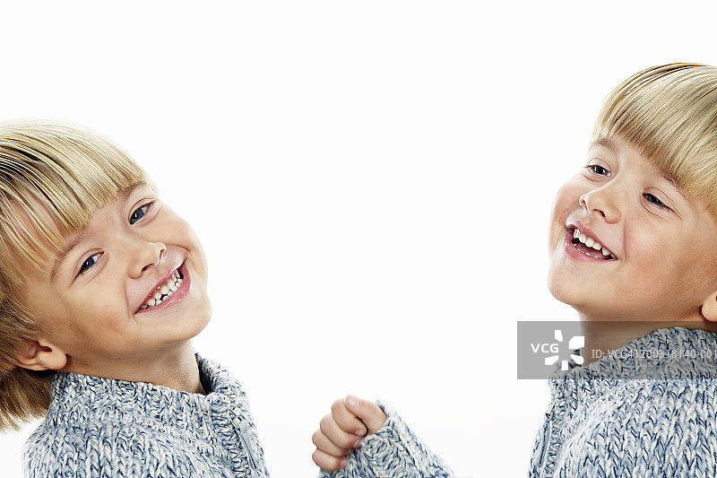 双胞胎男孩(3-5)微笑着，头向后倾斜，肖像，特写图片素材