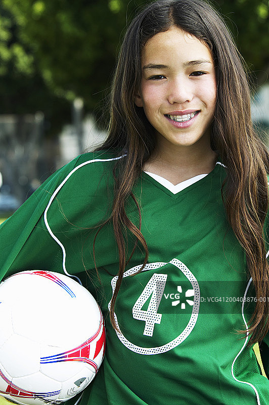 女足球运动员(11-13)，腋下足球，微笑，肖像图片素材