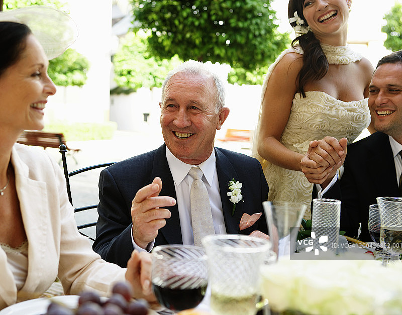 新郎新娘与父母同桌，面带微笑图片素材