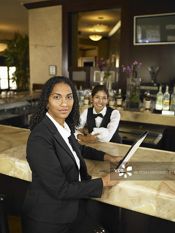 酒店经理由女调酒师，面带微笑，画像图片素材