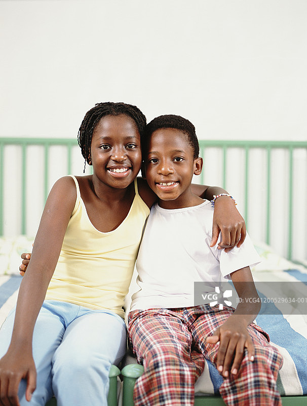 弟弟和妹妹(8-14)坐在床上，画像图片素材