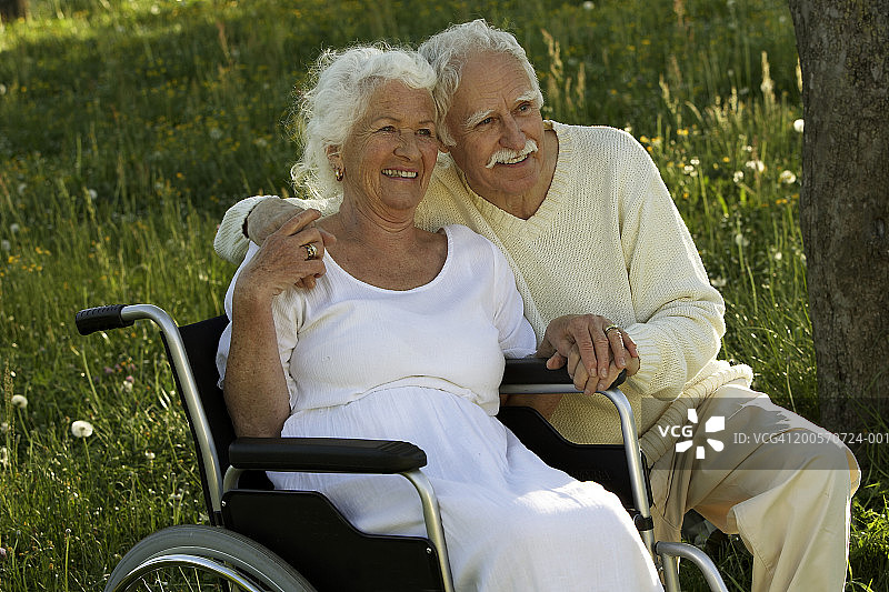 公园里一对老年夫妇，一男一女坐在轮椅上图片素材