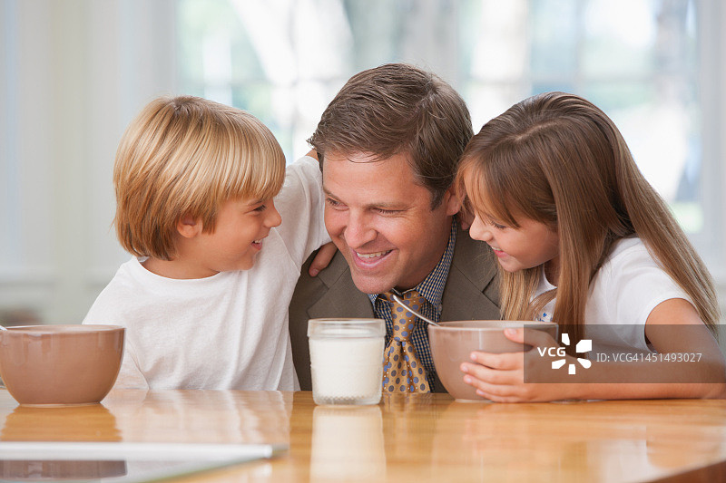 一个男人和两个小孩在厨房里聊天图片素材