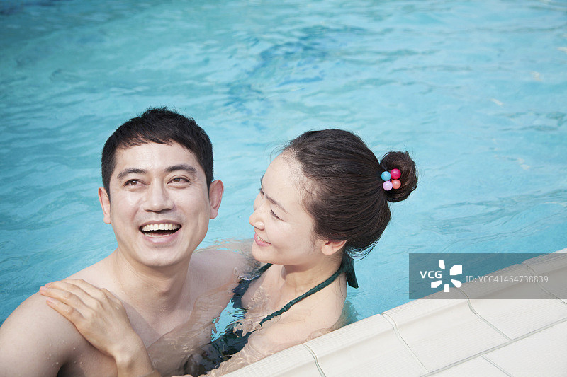 幸福的情侣在泳池里微笑放松图片素材
