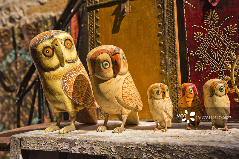 印度拉贾斯坦邦贾伊萨尔默的市场摊位上出售的木制猫头鹰雕塑图片素材