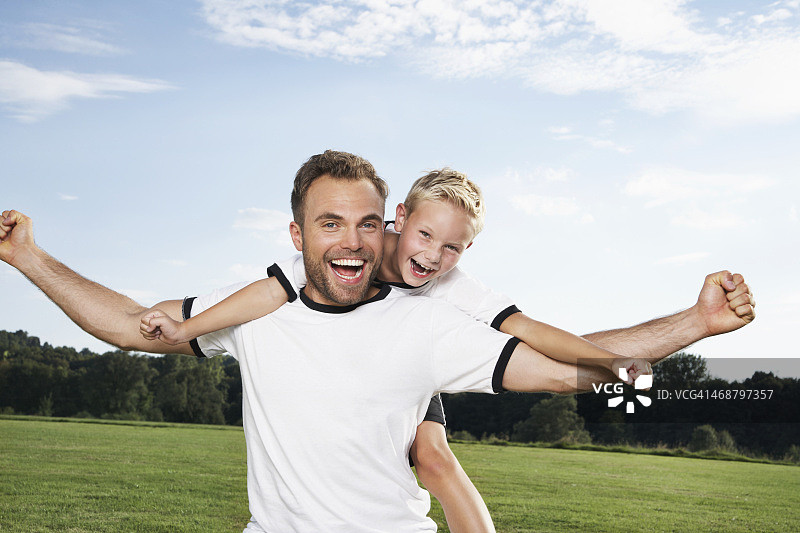 德国，科隆，父亲和儿子穿着足球服欢呼图片素材