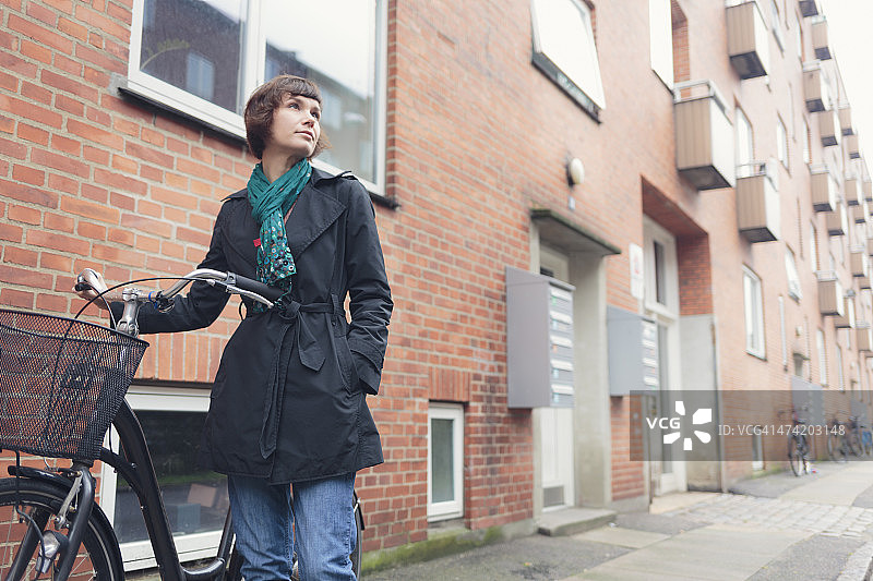丹麦哥本哈根，一名骑着自行车的妇女。图片素材