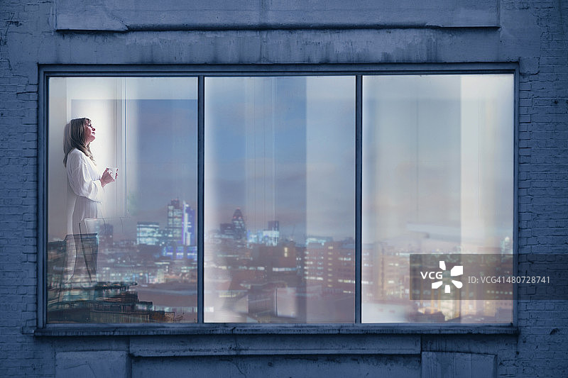 一个女人在她城市公寓的窗前休息图片素材