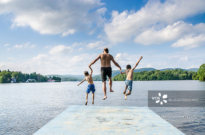 父亲和儿子在湖里跳图片素材