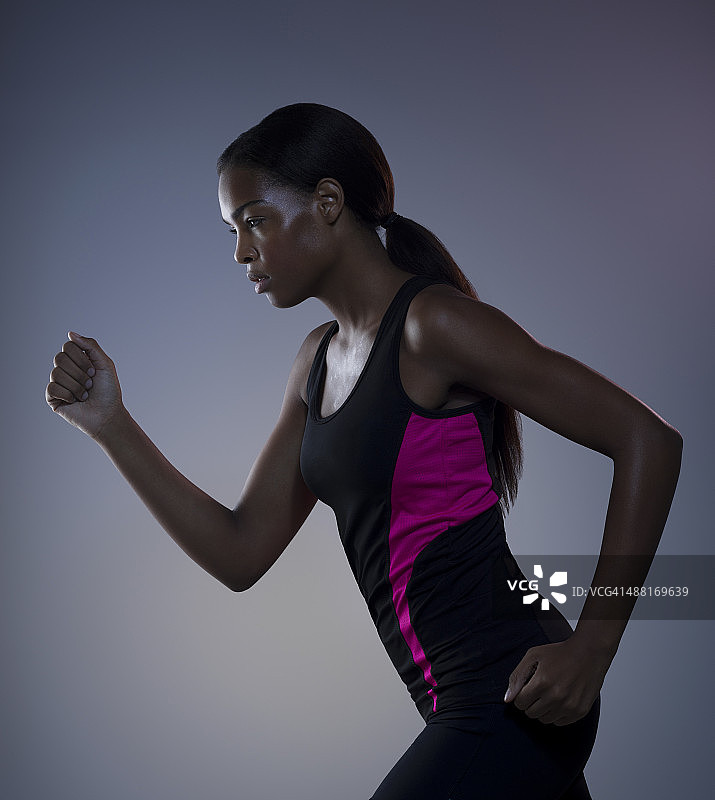 深色皮肤女性跑步，侧视图片素材