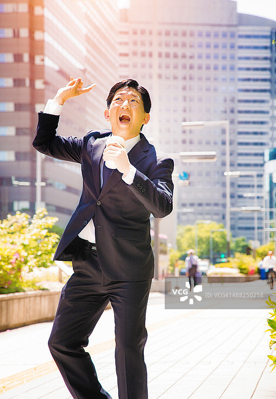 欣喜若狂的日本商人在东京街头跳舞图片素材