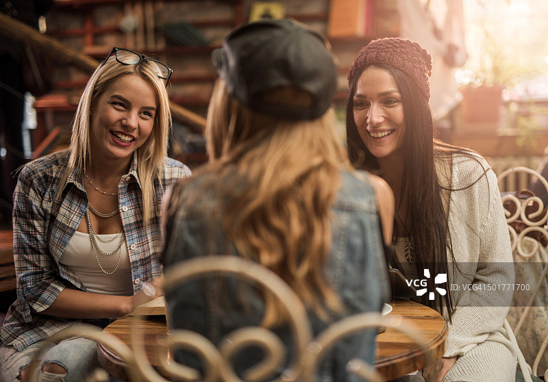 快乐的女人在咖啡馆里和朋友聊天。图片素材
