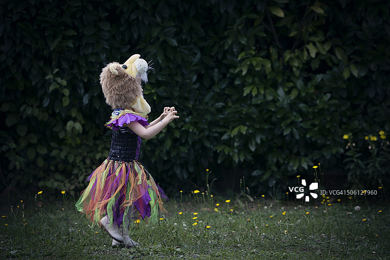 穿着万圣节服装的女孩在花园里奔跑图片素材