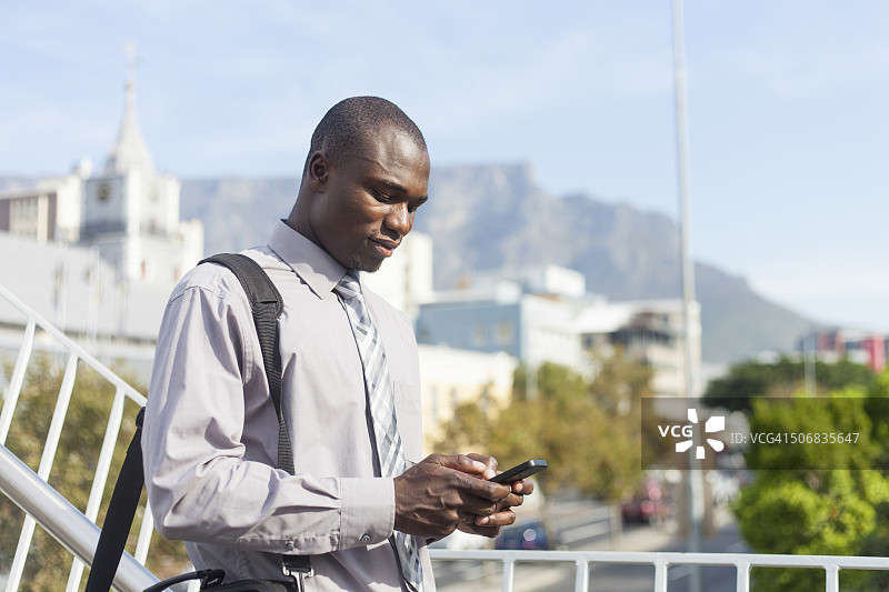 南非开普敦一名使用手机的非洲商人图片素材
